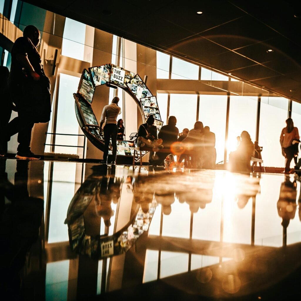 Silhouette of people enjoying sunset views from a modern skyscraper in New York City.